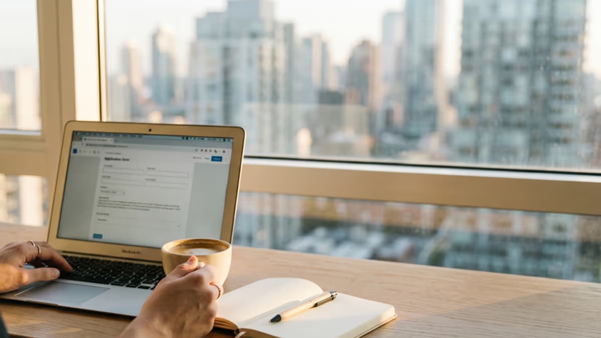 Empty modern coworking desk with laptop, plant, and coffee cup being cleared during a workspace transition