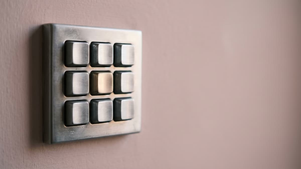 Close-up of a brushed steel keypad with blank keys under soft pink morning light