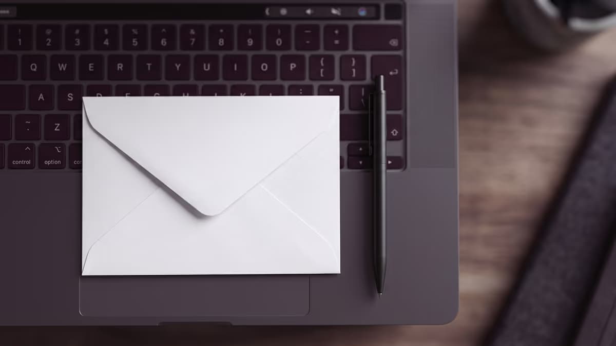 Blank envelope resting on a laptop keyboard, representing entering an address suite number into online forms