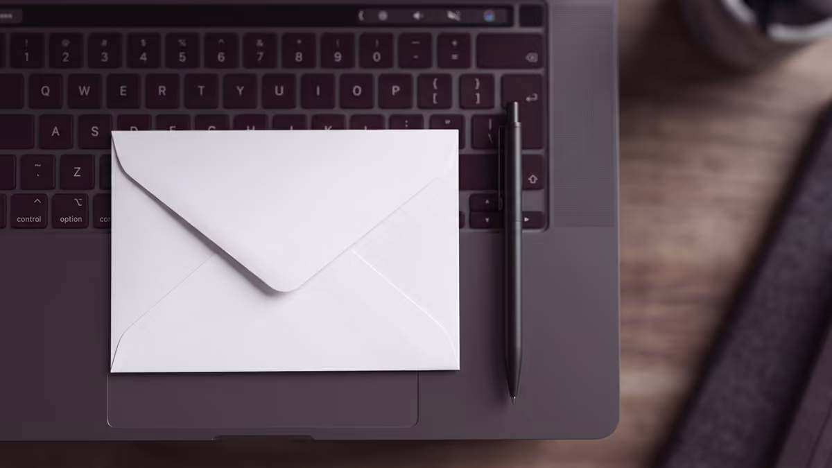Blank envelope resting on a laptop keyboard, representing entering an address suite number into online forms