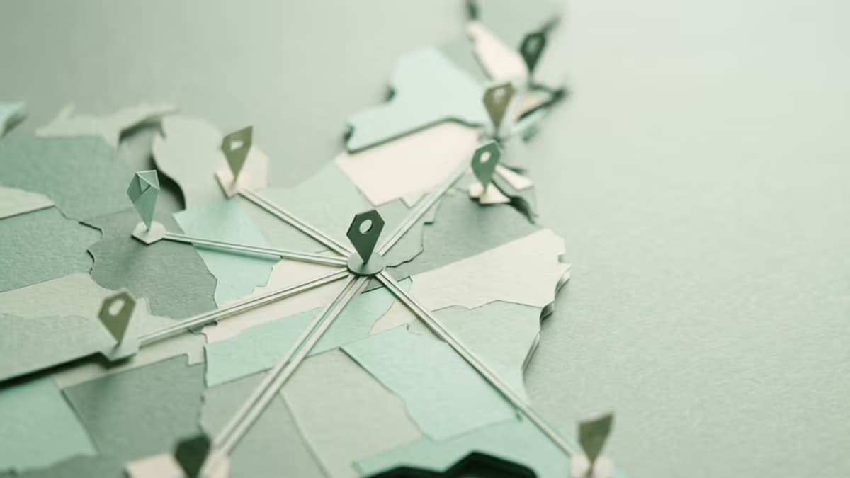 A wide, low-angle macro of a geometric paper map abstraction with route lines connecting several points across a muted green surface, soft directional light, editorial composition with negative space on the right