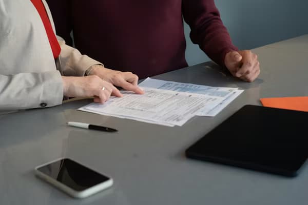 Professional signing LLC formation documents at a desk with legal paperwork